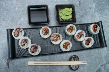 Chicken Teriyaki Maki Sushi Roll with Rice, Soy Sauce, Wasabi, and Chopsticks in platter top view of japanese food