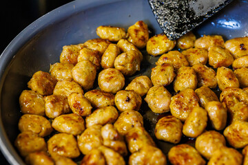 Delicious golden chicken meatballs frying in a pan ready to be served