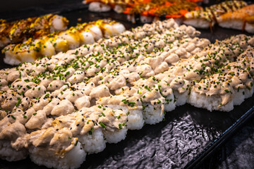 Delicious photo of sushi rolls served on a plate, including fresh fish, rice, and seaweed. Beautiful presentation with vibrant colors, perfect for food, culinary, and restaurant themes.