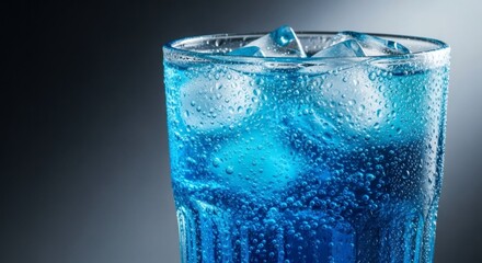 Refreshing summer beverage in a tall glass with blue liquid and ice cubes, ideal for food and drink promotions or advertisements.