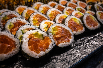 Delicious photo of sushi rolls served on a plate, including fresh fish, rice, and seaweed. Beautiful presentation with vibrant colors, perfect for food, culinary, and restaurant themes.