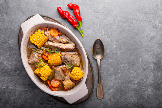 Chilean cuisine of Latin America. Traditional Chilean cazuela de cerdo. Pork soup with potatoes and corn, stew with corn and carrots on grey background top view copy space for text