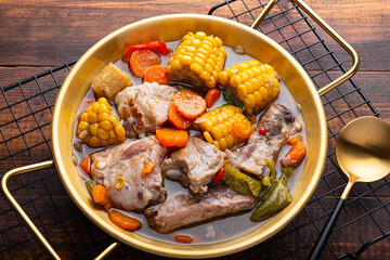 Chilean cuisine of Latin America. Traditional Chilean cazuela de cerdo. Pork soup with potatoes and corn, stew with corn and carrots on dark wooden background close up