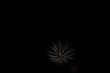 Fototapeta premium Fireworks on the dark sky background. Colorful fireworks. Abstract colored firework background with free space for text. fireworks light up the night sky. New year celebration fireworks 