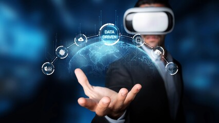 A businessman wearing a virtual reality headset engages with data visualizations, showcasing a blend of technology and innovation in a dynamic digital environment. Raster