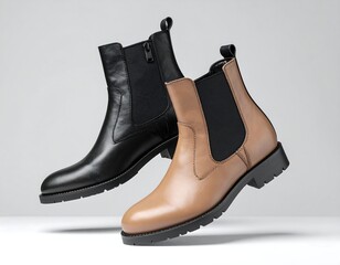 Two women's ankle boots, black and tan, on a light gray background.  They appear to be floating