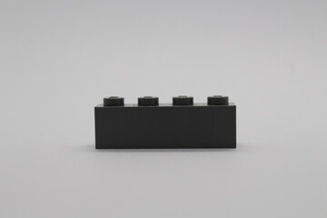 Naklejka premium Black Lego brick piece isolated on a white background 