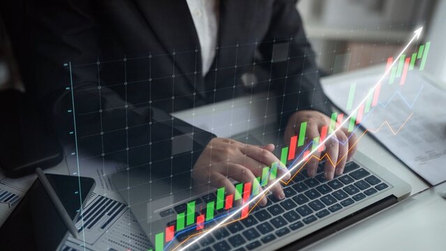 Business professional engaged in financial analysis using a laptop, with a digital graph overlay depicting growth trends and investment strategies for effective decision-making. Copula