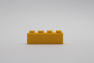 Naklejka premium Yellow Lego brick piece isolated on a white background 
