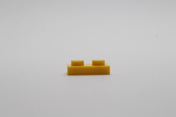 Obraz premium Yellow Lego brick piece isolated on a white background 