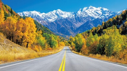 Fototapeta premium Road to Scenic Majesty: An open road invites exploration toward majestic snow-capped mountains in a vivid autumn landscape, evoking a sense of adventure and the beauty of nature's transition.