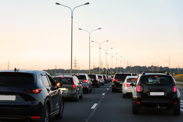 A Traffic Jam on the Highway During a Beautiful Sunset Evening Amidst the City Scenery