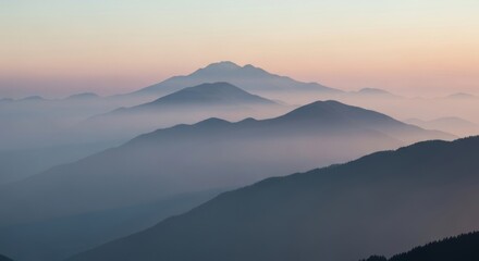 Obraz premium Layered misty mountains at sunset. Fog-shrouded peaks with colorful gradient sky. Serene atmospheric landscape evoking tranquility and nature's depth