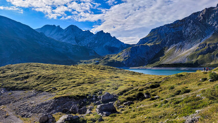 An exciting view of the mountain lake Lunersee in the frame of high Alps and green hills in Austria.