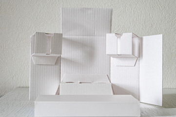 A surreal figure made of white folded cardboard. Podium for displaying products.