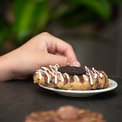 Chocolate dessert on plate served with hand holding fork.