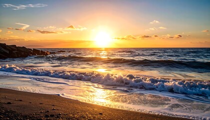 Obraz premium Golden sunset over a tranquil beach. Waves gently lap at the shore as the sun dips below the horizon