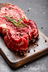 Big piece of fresh uncooked red meat on a wooden cutting board