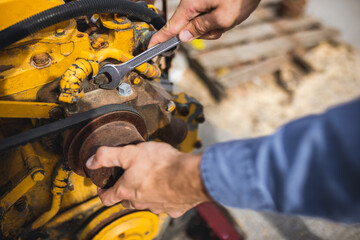 Young mechanic repairing truck and excavator engines