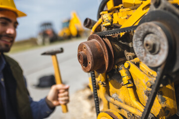 Young mechanic repairing truck and excavator engines
