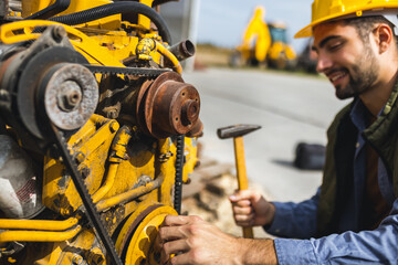 Young mechanic repairing truck and excavator engines