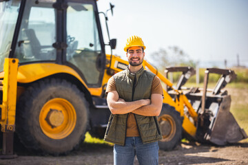 Young excavator operator standing in front of excavator