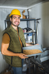 Young worker sampling wheat before storage