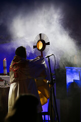 Priest holding the Blessed Sacrament of the Eucharist,
