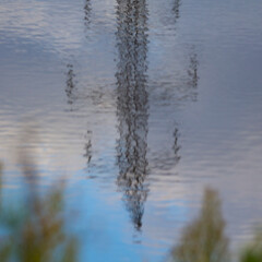 Fototapeta premium A mirror image of a power transmission tower reflected on the surface of the water.