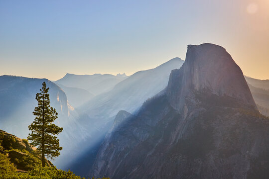 Half Dome Sunrise Sunbeam and Pine Tree Yosemite National Park Scenic View - Powered by Adobe