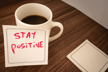 A positive message on a sticky note, on a cup of coffee.