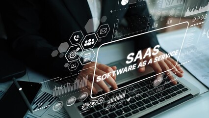 Professional hands typing on laptop with software as a service concept and digital data overlay in modern office setting. Asymptotic smart data analytic.