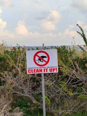 Pet waste prohibition sign in natural area, clean it up message, environmental awareness and public notice