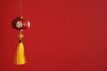 Red lantern with floral pattern and yellow tassel. Classic Chinese decoration symbolizing joy and good fortune.