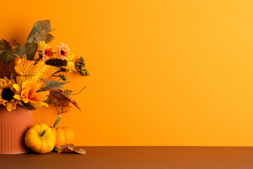 Terracotta vase with fall foliage and pumpkins on brown surface. Ideal for seasonal promotions, Thanksgiving, or cozy autumn decor.