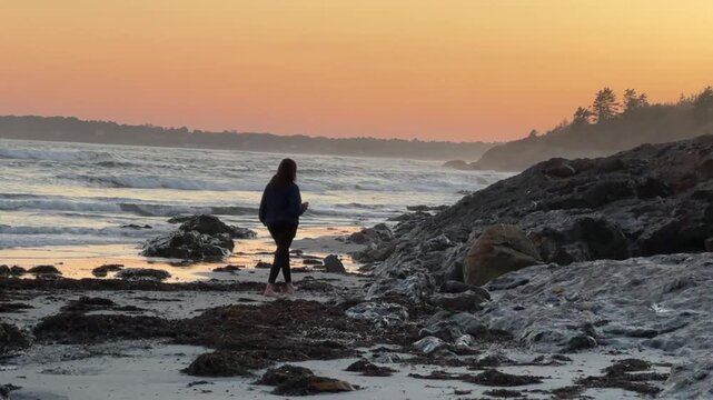 Woman Walking on the Beach Holding a Cocktail Glass