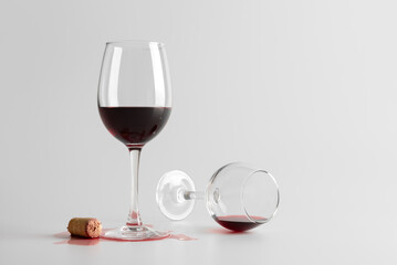 Spilled Red Wine Glass with Cork on White Background