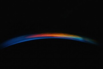 Celestial Arc of Colors: A captivating, high-angle view of the Earth's atmosphere during sunrise or sunset, displaying a breathtaking array of colors across a black expanse.
