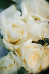 Wedding rings resting on a bouquet of white roses and eucalyptus. Symbol of love, fidelity, and celebration. Elegant floral composition in natural light.