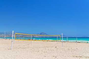 Playa de San Juan beach in Alicante city, sports area with volleyball net on sandy beach of Mediterranean Sea coast Costa Blanca in sunny summer day, mountain range, Valencian Community, Spain