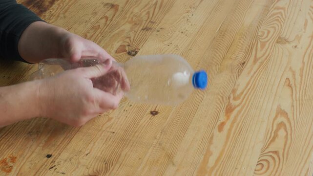 Plastic Bottle Crumpling on Wooden Table &ndash; Real Foley Sound, Hands Close-Up