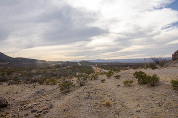 Explore rugged desert landscapes beneath a cloudy sky with mountains in the distance ideal for travel, adventure, and outdoor lifestyle projects