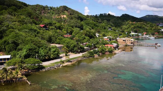 Tropical island in the Caribbean Sea coastal road and houses spread on the slope of the hill facing the waterfront