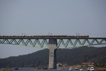 A freight train loaded with timber crosses the Catoira railway bridge in the Arousa estuary, Galicia.