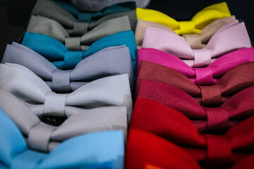 A colorful display of bow ties arranged by hue, featuring shades of blue, gray, red, pink, yellow,...