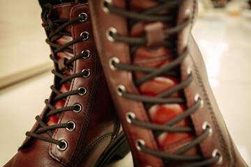 Classic brown leather combat boots with black laces and a rugged sole, combining durability with...