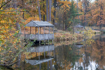 Wooden arbors on the shore of a picturesque autumn lake