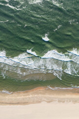 Aerial View of Serene Coastal Beach with Ocean Waves and Grassy Terrain
