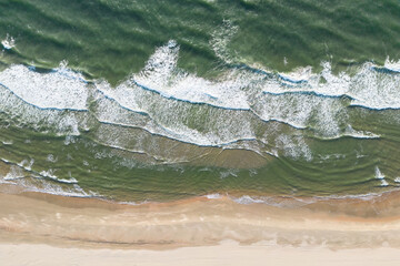 Aerial View of Serene Coastal Beach with Ocean Waves and Grassy Terrain