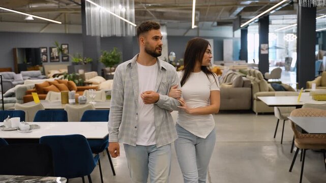 Newlyweds couple choosing new furniture in a store